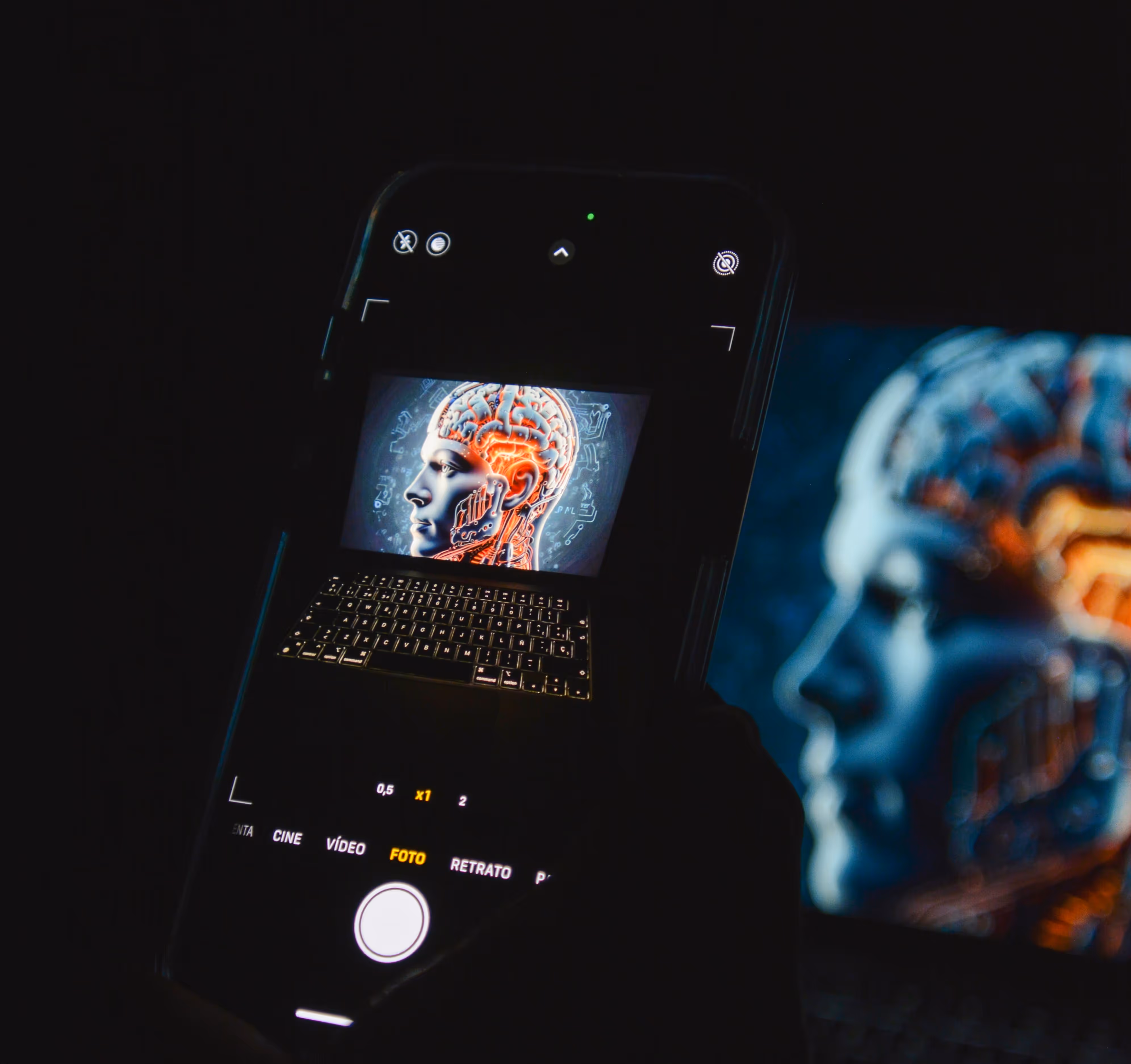 Sebuah smartphone menangkap gambar hasil AI berupa kepala manusia dengan sirkuit otak yang menyala ditampilkan di layar laptop, melambangkan kecerdasan buatan dan inovasi digital.