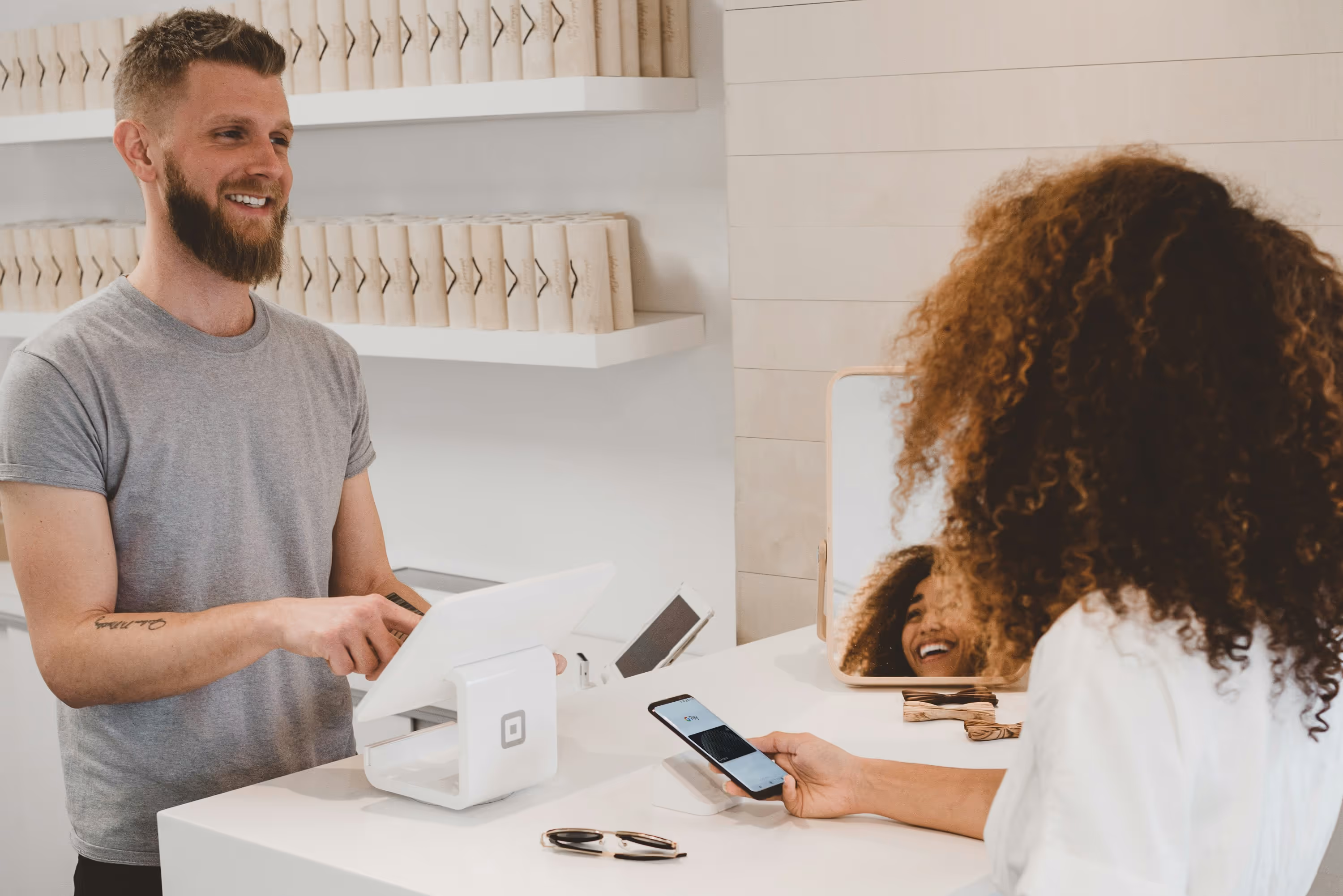 Man in grey t-shirt smiling to a woman on counter